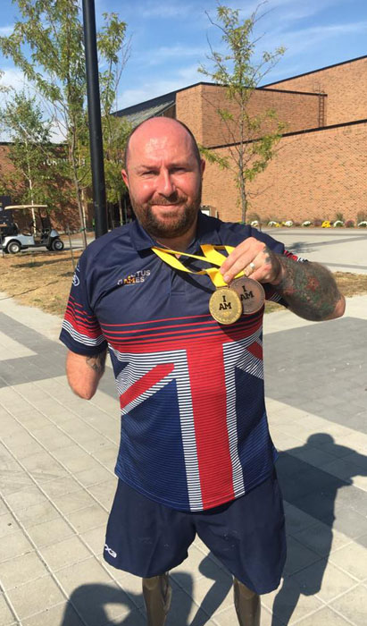 Dave proudly shows his bronze and gold Invictus Games medals